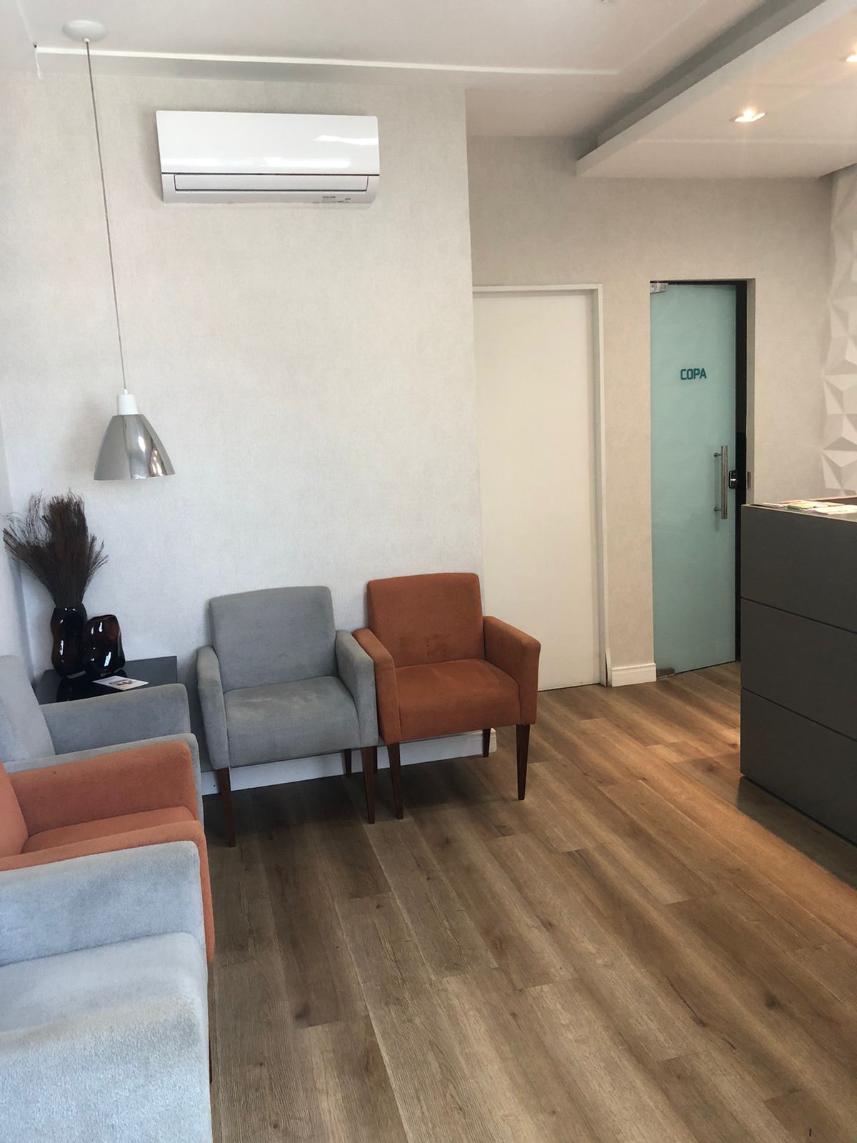 Recepção da clínica do Dr. Thiago Tapioca, com poltronas e ambiente climatizado, no Centro de Feira de Santana